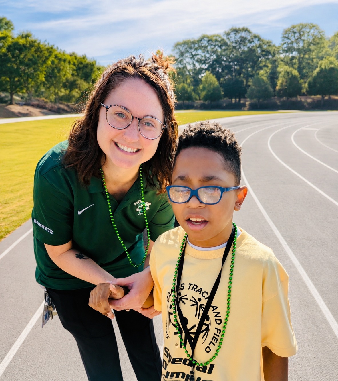 Foundation founder with a participant at a Special Olympics track and field event